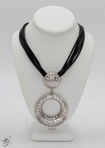 SILVER HAMMERED METAL NECKLACE ADORNED WITH LAYERS OF SILVER RHINESTONES ON A STURDY MULTI STRING BLACK CHORD