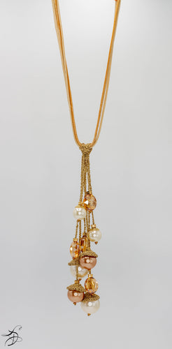 TRELLIS OF SMALL & MEDIUM SIZE IVORY AND AMBER PEARL BALLS INTERTWINED ON A GOLDEN 16 INCH CHORD