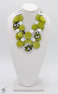 THREE LAYERS OF A BEAUTIFUL AND UNIQUE GREEN, BLACK AND WHITE SPOTTED CIRCLED PEBBLES WITH A WHITE BUTTON AND WHITE CHORD CLOSURE.  ONE OF A KIND NECKLACE THAT LAYS LIGHT ON THE NECK.